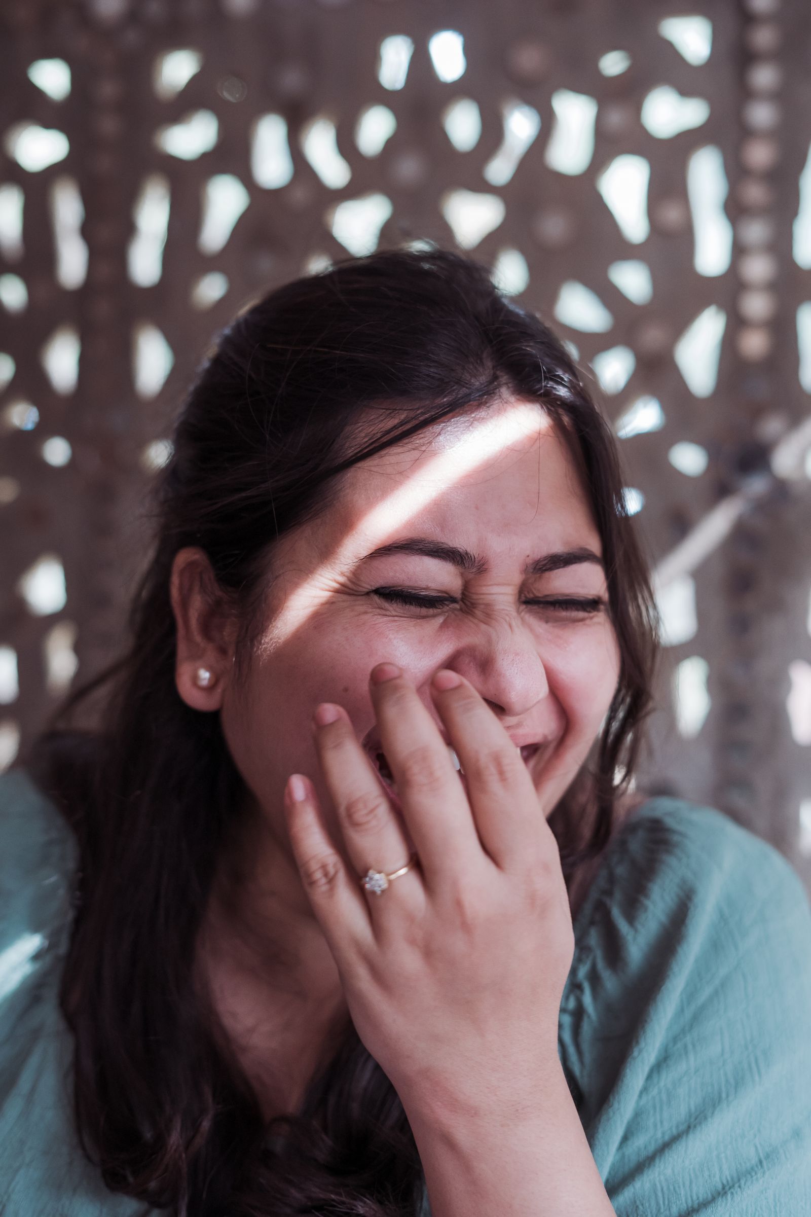 Mujer riéndose y tapándose la boca con la mano