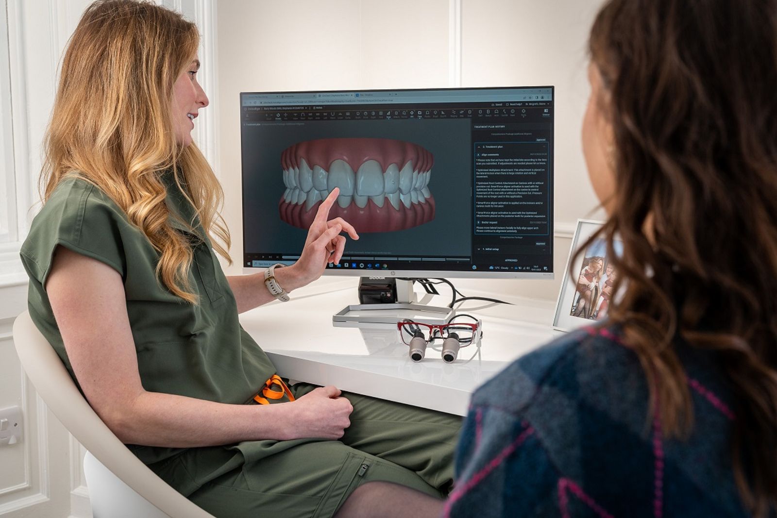 Odontóloga mostrando en pantalla un modelo 3D de los dientes a una paciente
