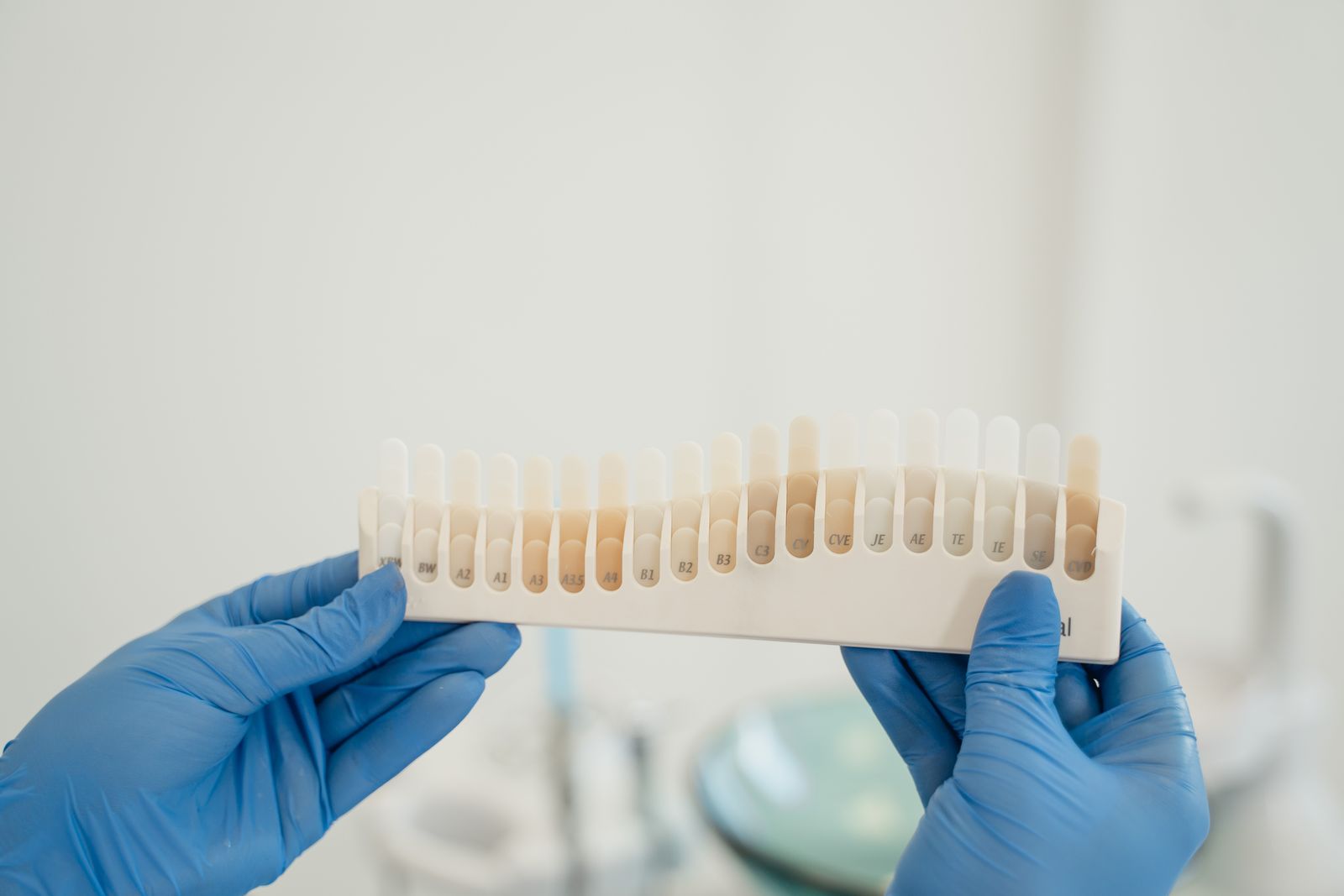 Guía de tonos dentales sostenida por manos con guantes